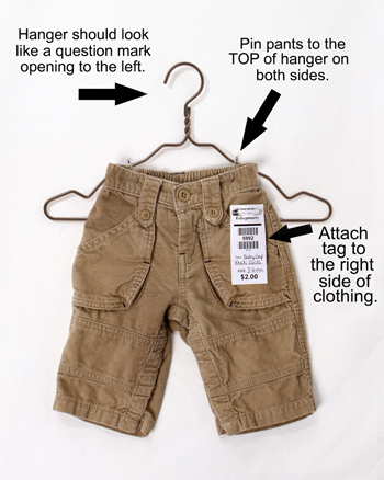 Hanger should look like a question mark opening to the left.  Pin pants to the TOP of hanger on both sides. Atach tag to teh right side of clothing.